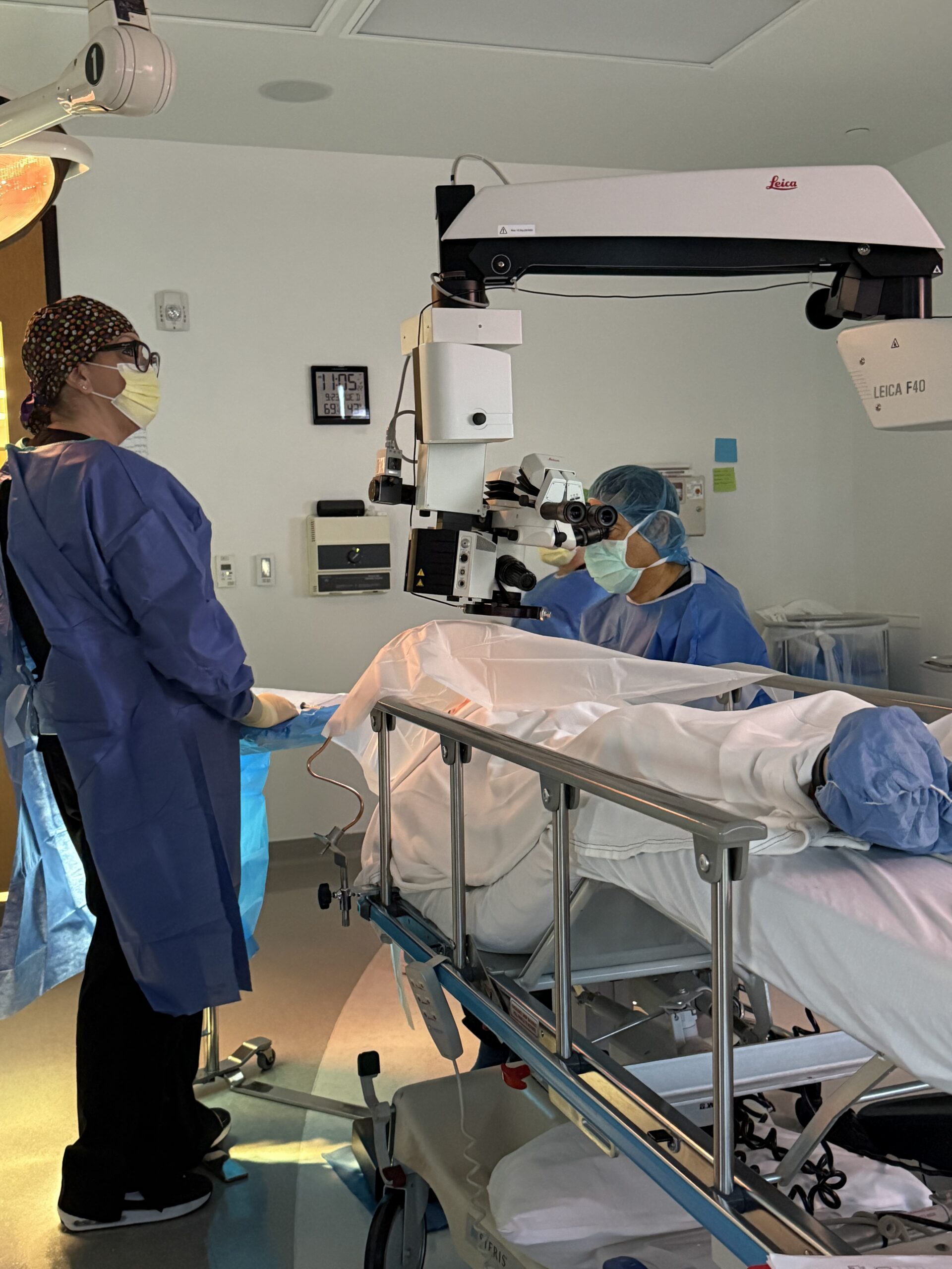 A Hoopes Vision surgeon and surgical team performing eye surgery under an operating microscope